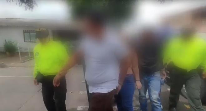 Personas capturadas-policías custodiando