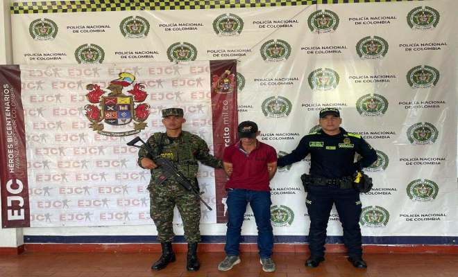 Funcionario del ejército en la parte izquierda, en el centro un hombre capturado y en la derecha un funcionario de la policía nacional