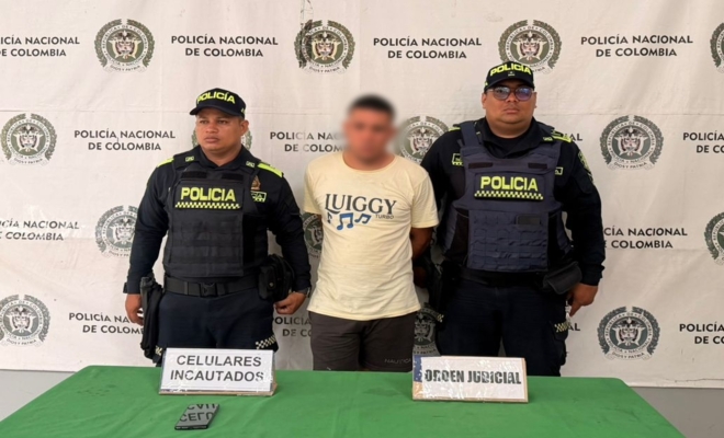Dos polic&iacute;as custodian a un hombre capturado por presunto homicidio