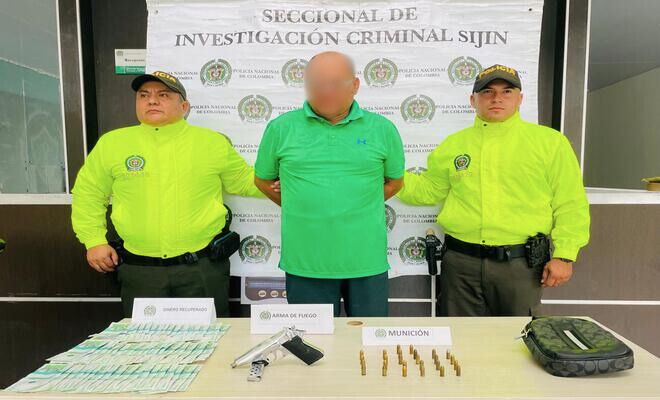 Dos Uniformados de la Policía Nacional de Colombia junto a un capturado. Se observan elementos incautados como dinero en efectivo, un arma de fuego, munición y una motocicleta utilizados en el hecho delictivo.