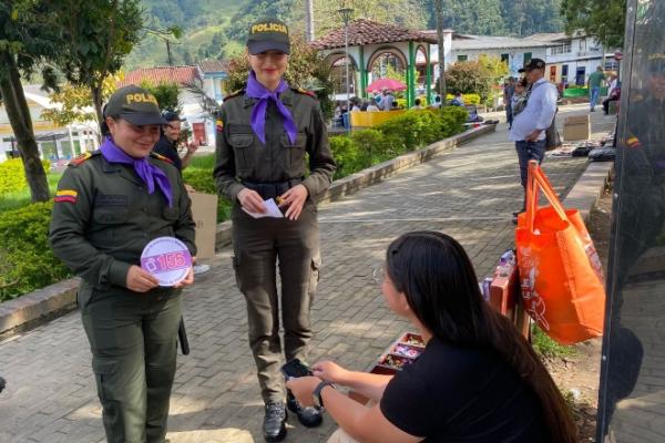 Policía en Caldas, entregó un detalle especial y una cintilla color púrpura, promocionando la línea 155