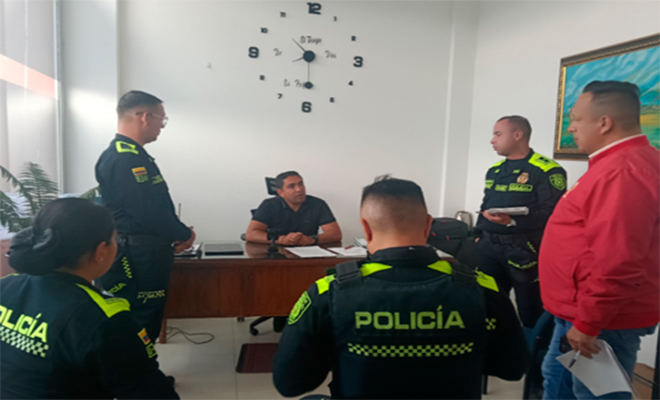 reuni&oacute;n de dos persona y cuatro polic&iacute;as.