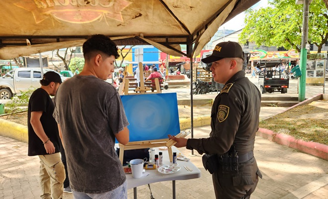 Policía entregando los pinceles para pintar en el lienzo