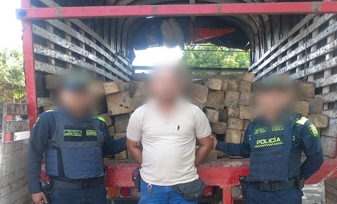 Dos policías y un capturado y un camión con madera incautada