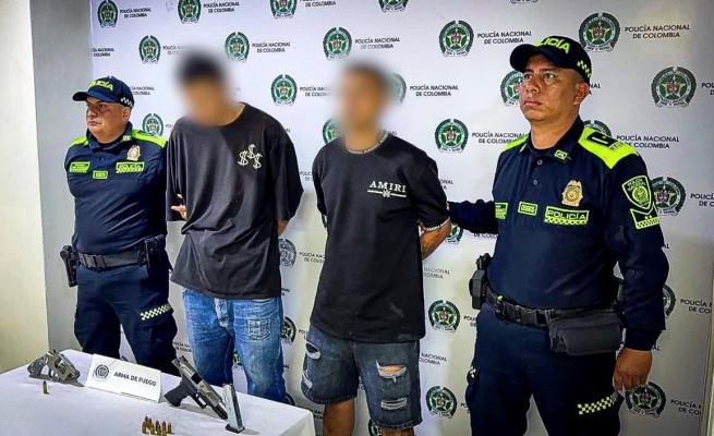 Dos polic&iacute;as con  dos personas Capturadas y armas de fuego incautadas