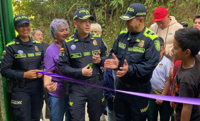 Polic&iacute;as y comunidad cortan el list&oacute;n durante la reinauguraci&oacute;n de la escuela rural.