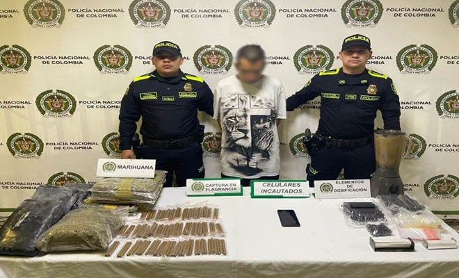 Dos polic&iacute;as con un Capturado en banner con mas de 7 kilos de marihuana incautada