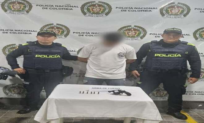 Dos policías junto con una persona capturada