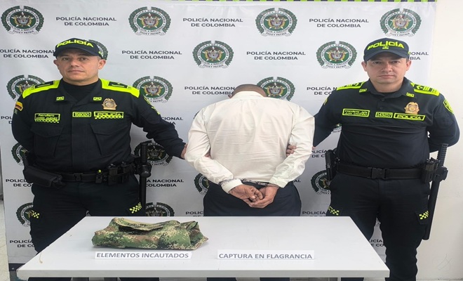 Dos policías con un capturado con uniforme institucional
