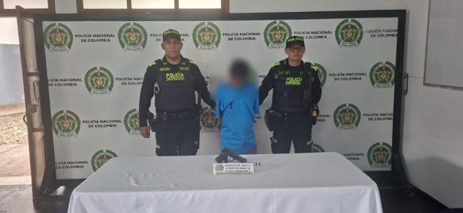 Hombre capturado de camiseta celeste en medio de dos Policias