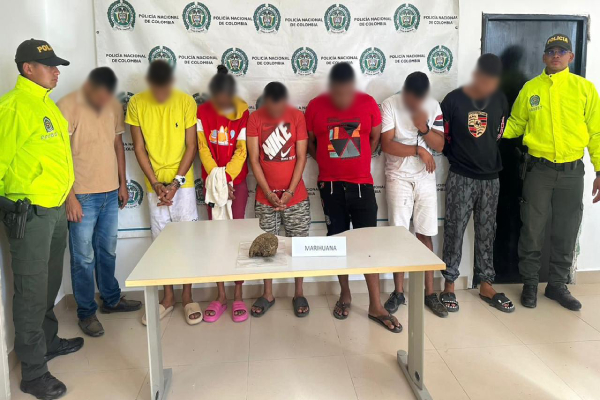 Personas capturadas-policías custodiando