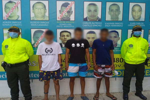 3 personas capturadas-policías custodiando