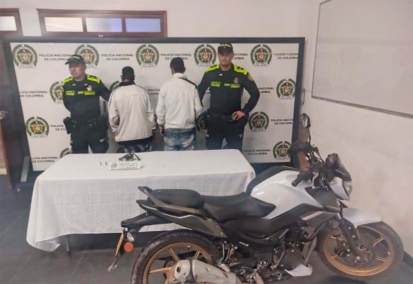 Dos hombres capturados en medio de dos polic&iacute;as, con arma de fuego y una motocicleta incautada