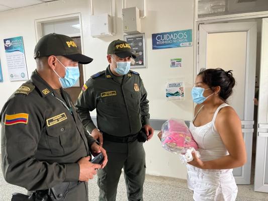 Policía entregando regalo a mamá del bebe recién nacido