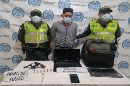 una persona capturada-policías custodiando-arma de fuego y munición incautada 
