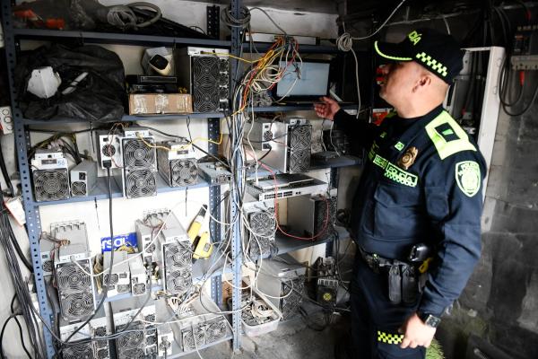 Policía verificando equipos de computo
