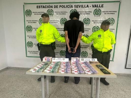 dos policías al lado de un capturado