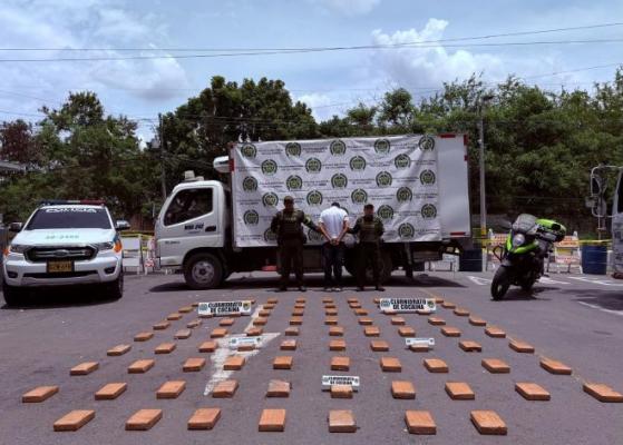 Dos policías al lado de un hombre capturado con clorhidrato de cocaína