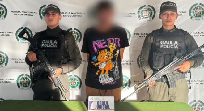 dos policías al lado de un hombre capturado por orden judicial 