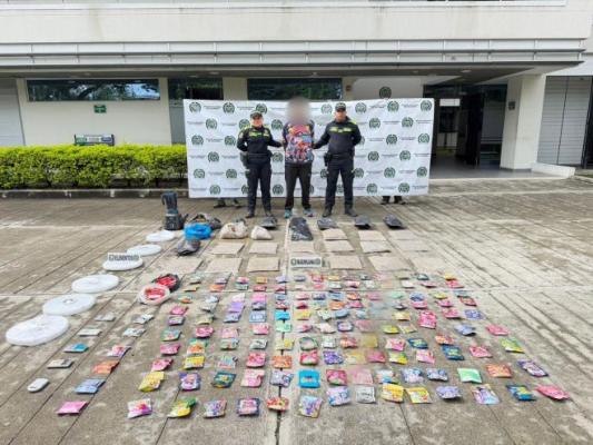 Dos polic&iacute;as al lado de un hombre con estupefacientes