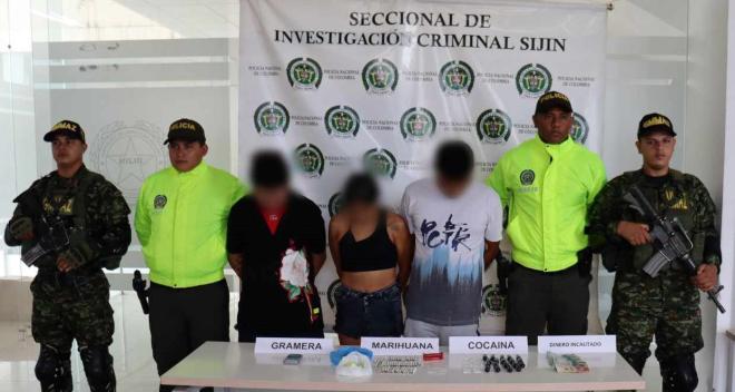 Personas capturadas-policías custodiando