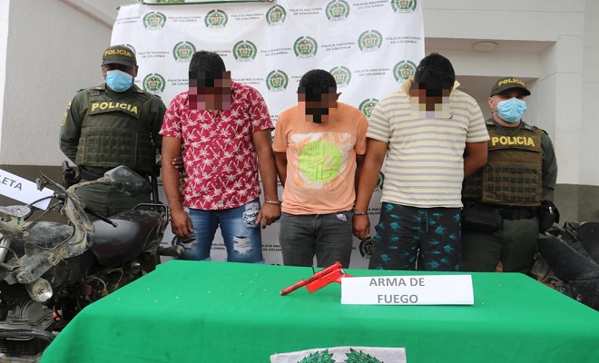 Personas capturadas-policías custodiando