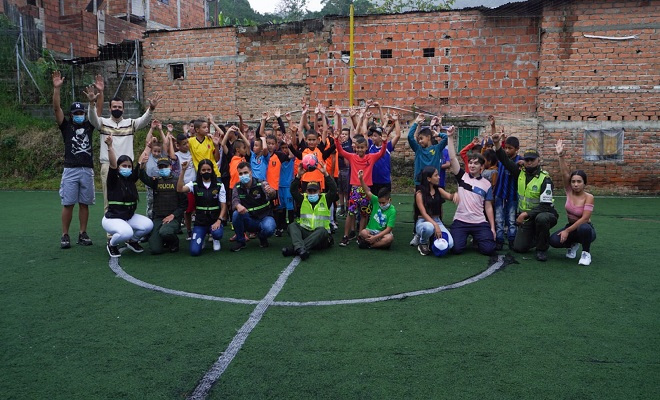 Niños celebrando en una cancha de fútbol sintética 