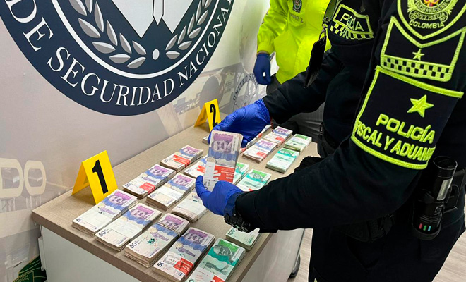 Un polic&iacute;a revisando billetes incautados 