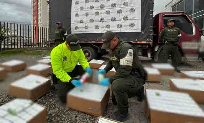 Dos policías revisando frascos de ketamina incautados