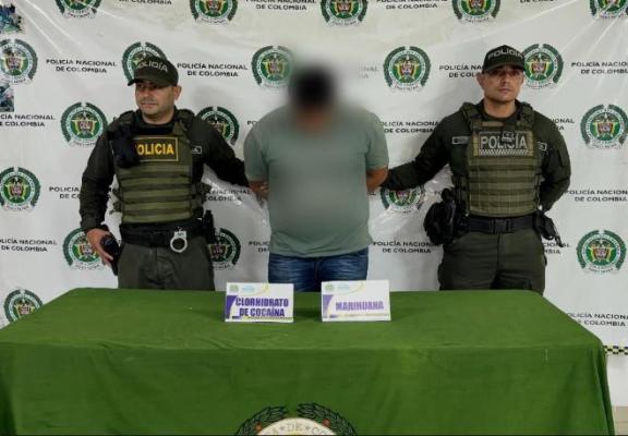 Dos polic&iacute;as al lado de un hombre 