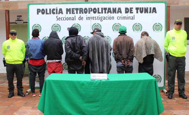 Personas capturadas-policías custodiando