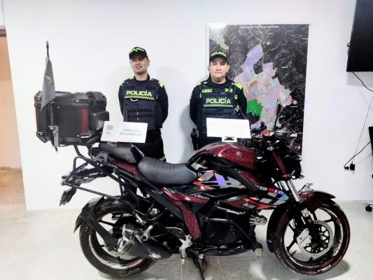 Dos Policias, en frente motocicleta recupedrada