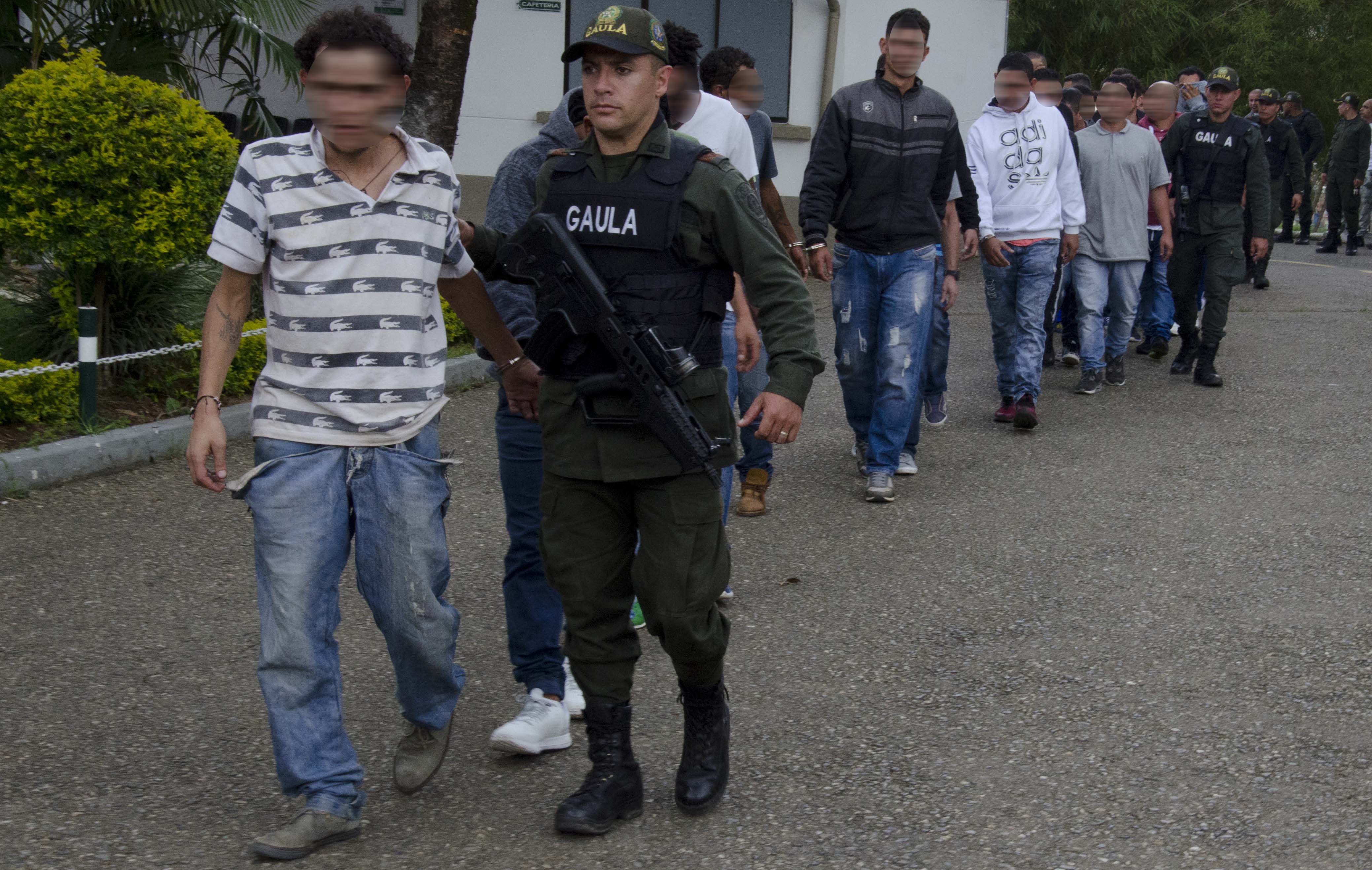 Policías conducen a capturados de operación contra la extorsión en Medellín