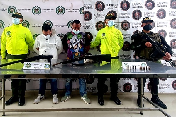 2 personas capturadas-policías custodiando armas de fuego incautadas