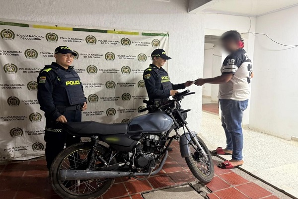 Dos Polic&iacute;as haciendo entrega de una motocicleta recuperada al propietario en Palermo 