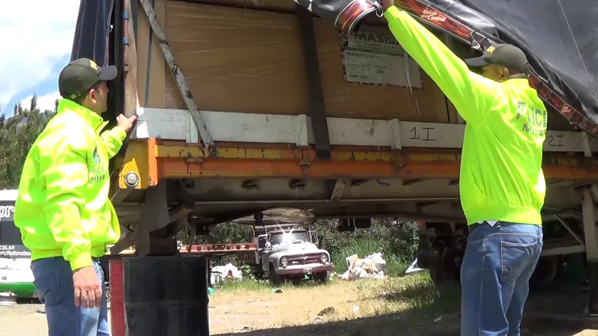 Dos policías revisan camión cargado con madera 